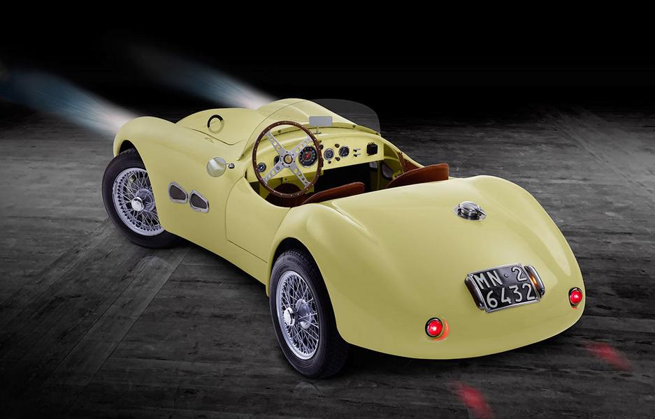 FIAT 500 Graziani MM Heck Ein klassisches, gelbes Sportauto mit offenem Design und einer hölzernen Innenausstattung. Das Fahrzeug hat Drahtspeichenräder und eine Motorhaube mit einem runden Emblem. Das Nummernschild ist gut sichtbar. Der Hintergrund ist dunkel, was das Auto hervorhebt.
