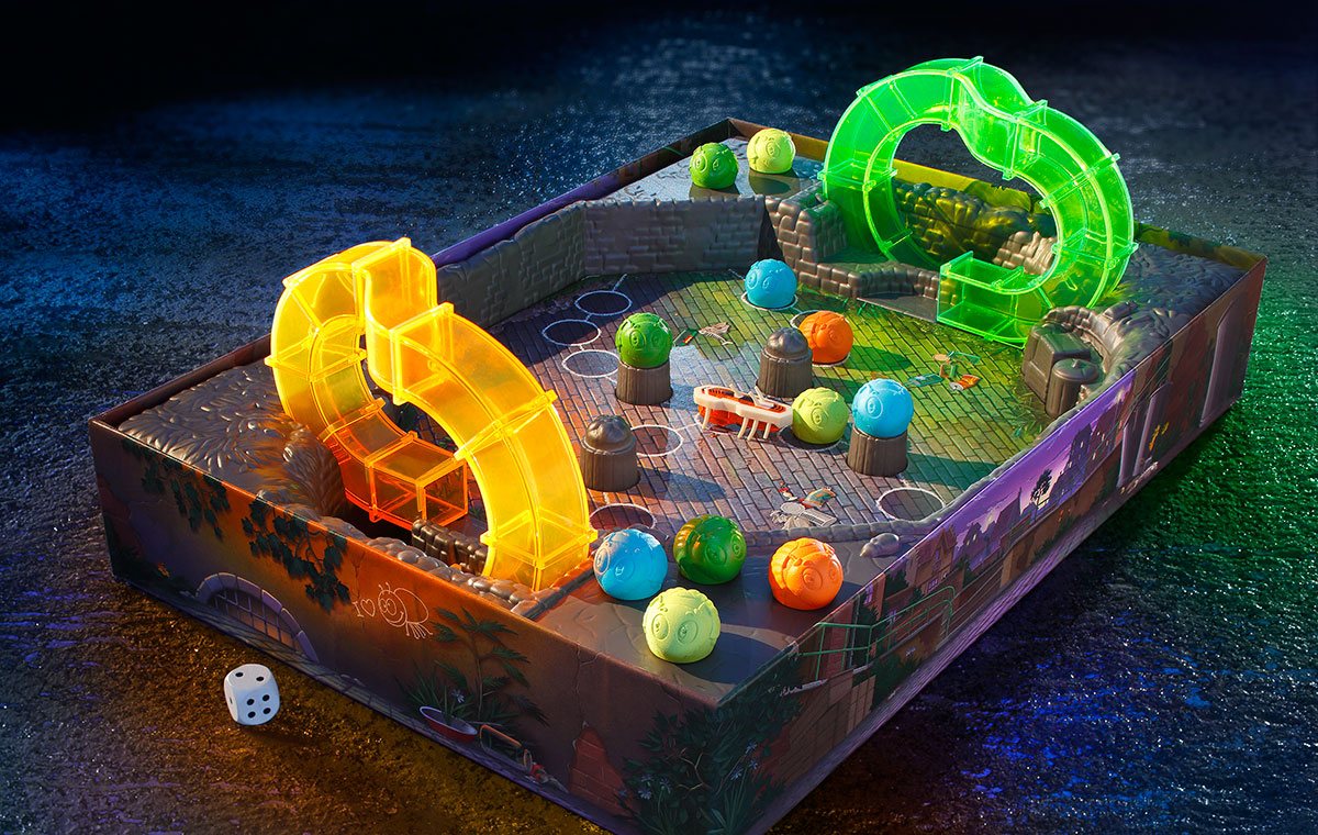Ein Brettspiel mit einer farbenfrohen Spieloberfläche, auf der sich bunte Kugeln befinden. Zwei transparente, leuchtende Tunnel sind in der Mitte platziert. Ein Würfel liegt neben dem Spielbrett.